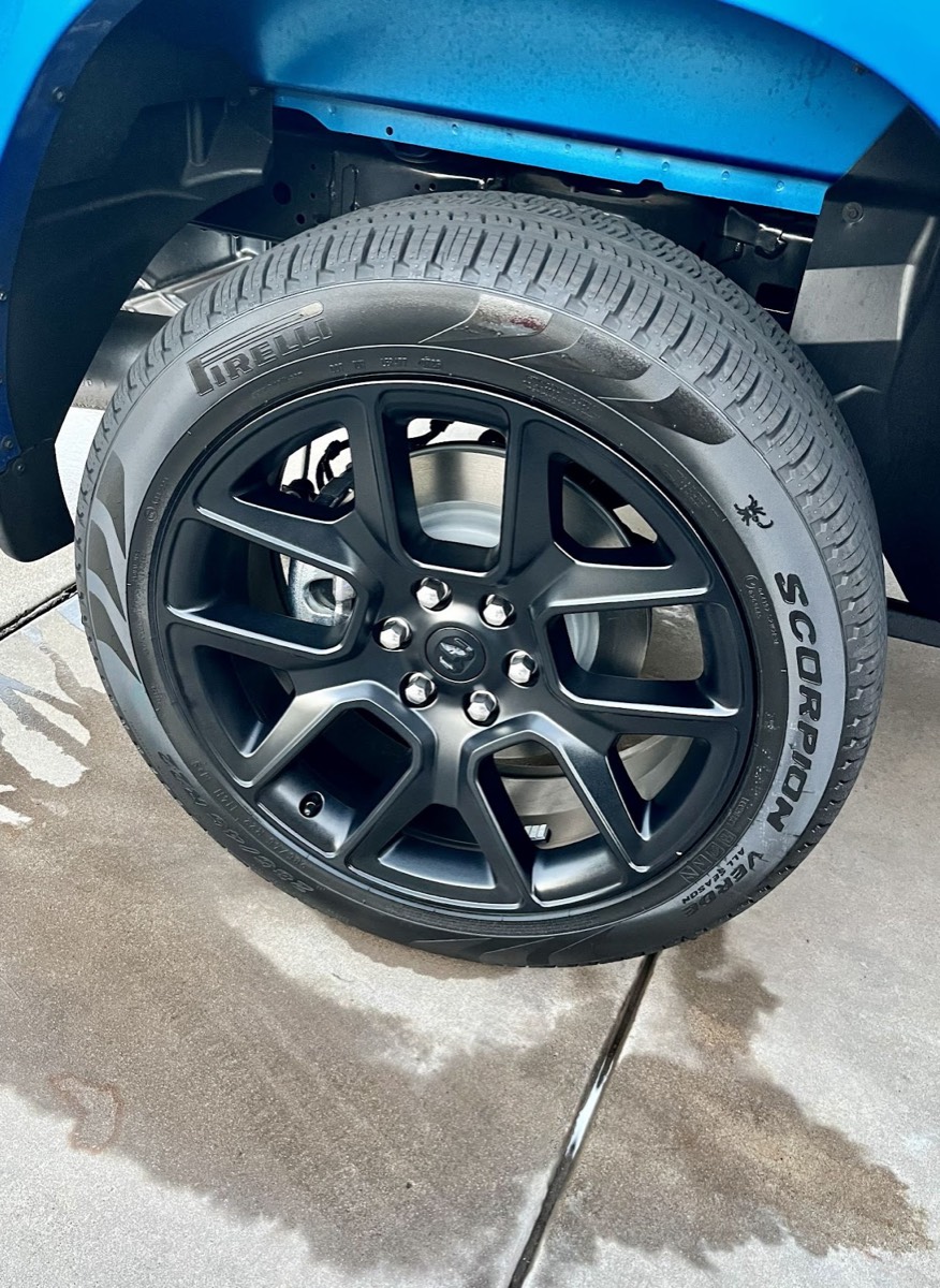 Close-up of a cleaned black alloy wheel and dressed tire
